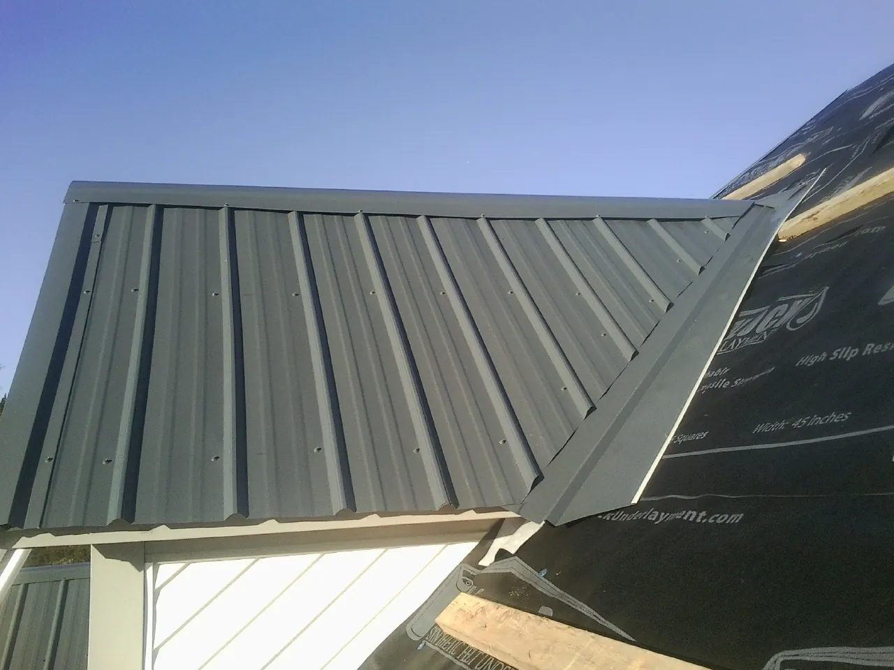 Gray metal roof panels going on over a garage gable in Studio City