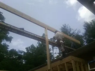 Carpenter setting a ridge beam over a new addition frame — Ice Dam Removal by Roofing Brothers in Studio City