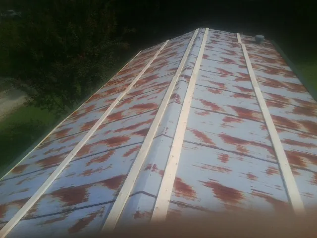 Rusted metal roof panels with new wood purlins before replacement — Storm Damage Roof Repair in Studio City by Roofing Brothers